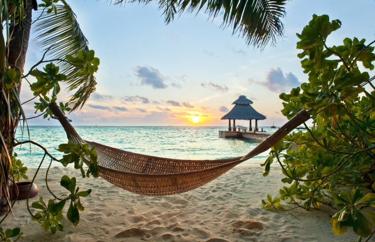 Empty hammock in the tropical beach in the Maldives at sunset